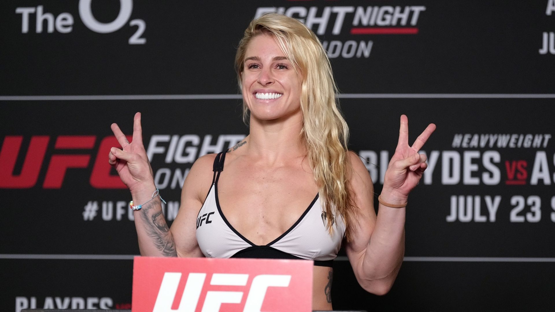 UFC fighter Hannah Goldy spreads her legs in front of the pole