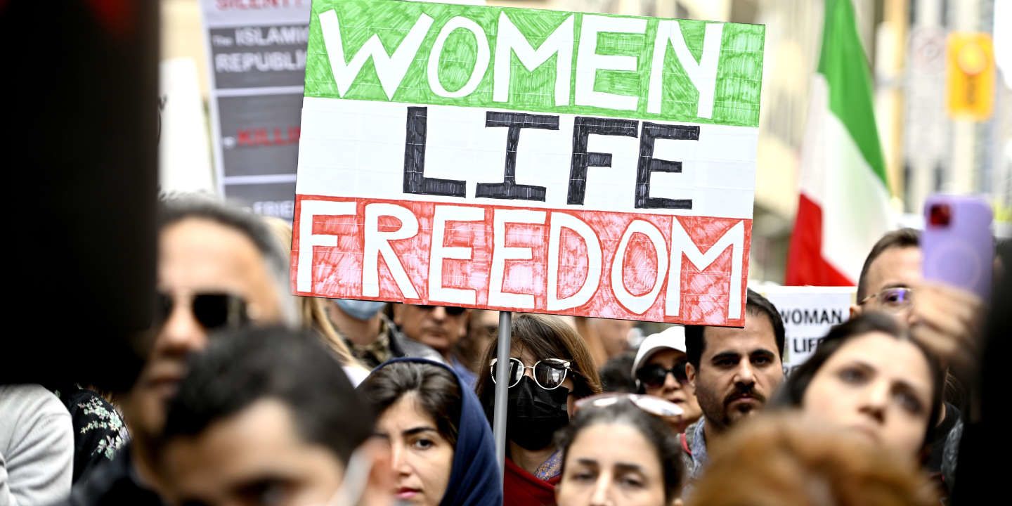 Security guards confiscate the flag with inscriptions &quot;Woman. Freedom. Life&quot; from Iranian fan before the 2022 World Cup match with Wales