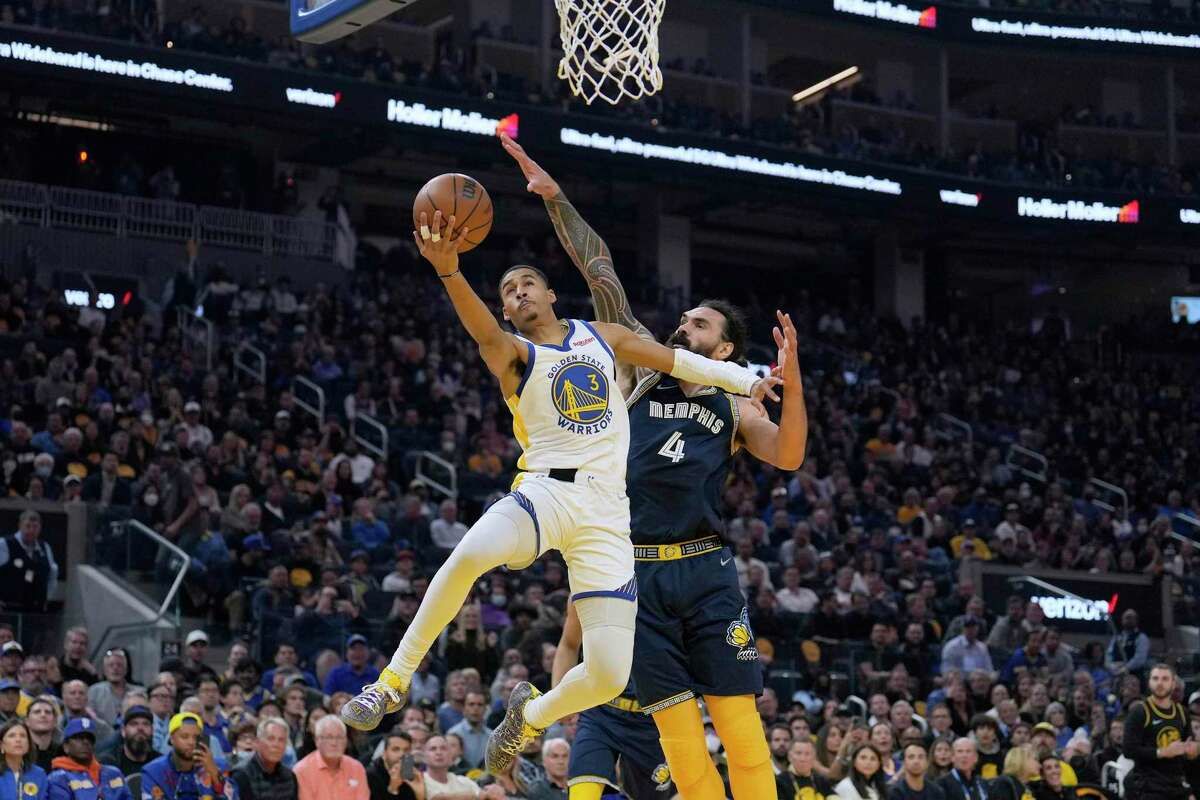 Jordan Poole goes up for  layup as Steven Adams contests (Memphis Grizzlies vs Golden State Warriors)